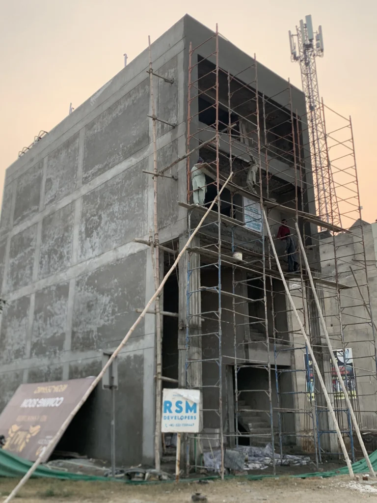 Heavy machinery like cranes and excavators in action at a Lahore construction site by the best construction company in Lahore.